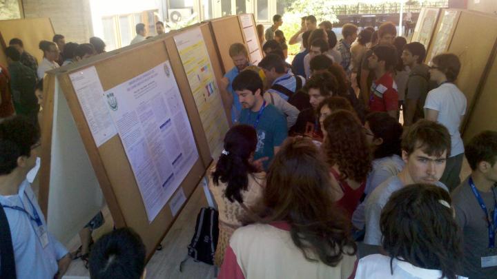 Participants in ICTP's 2012 summer school on Cosmology discuss each other's work at Wednesday's poster session at the Leonardo Building.