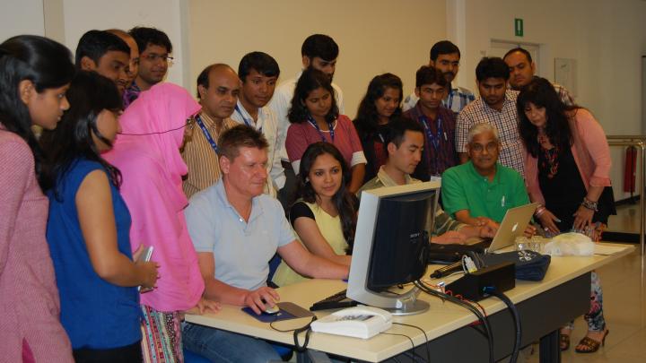 ICTP scientist Fred Kucharski (at the computer) with participants and conference organiser Jagadish Shukla (seated, right) 