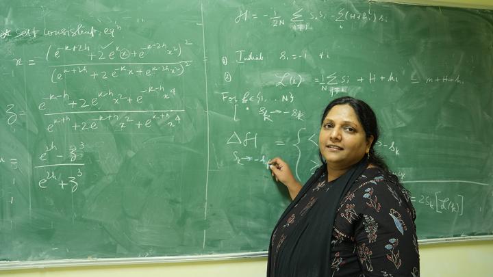 Image of researcher Sumedha Sumedha in front of a blackboard